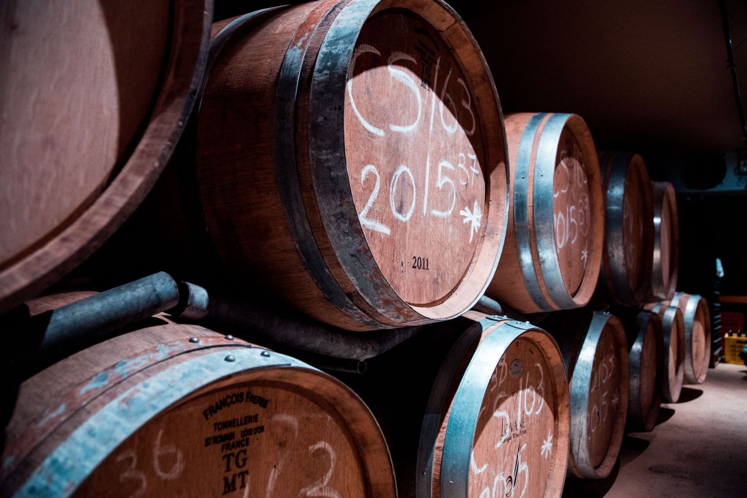 Große Weinbarrique-Fässer mit Jahrgangsangabe 2015 in Lagerhalle.